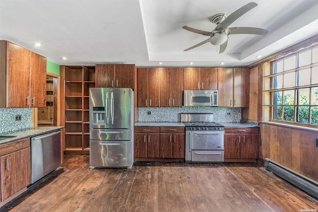 kitchen featuring a raised ceiling, stainless steel appliances, a baseboard radiator, and dark wood-type flooring