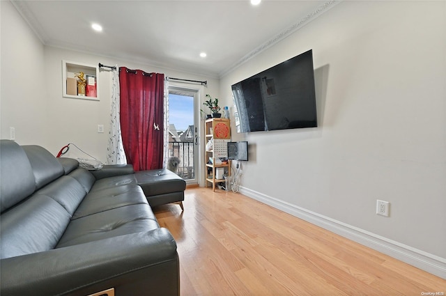 living room with light wood-type flooring and ornamental molding