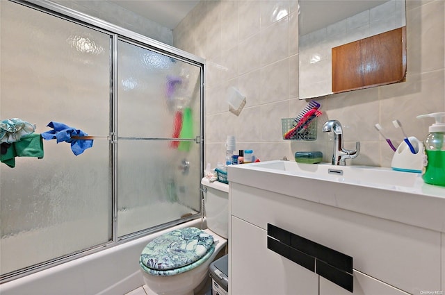 full bathroom with vanity, toilet, enclosed tub / shower combo, and tile walls