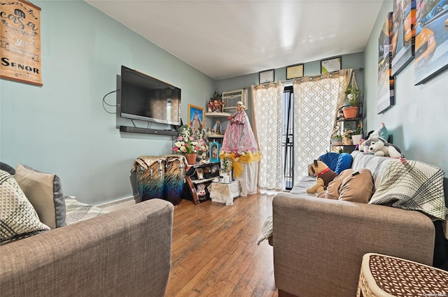 living room with a wall unit AC and wood-type flooring