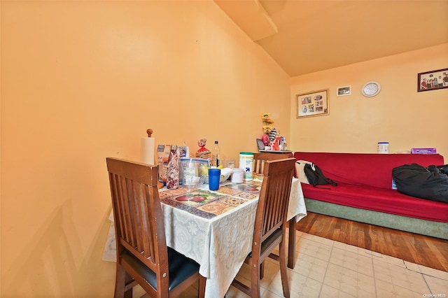 dining area featuring wood-type flooring and vaulted ceiling