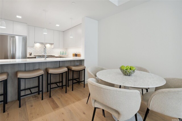 dining room with sink and light hardwood / wood-style flooring