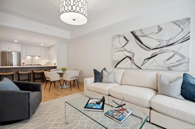 living room with light hardwood / wood-style floors and sink