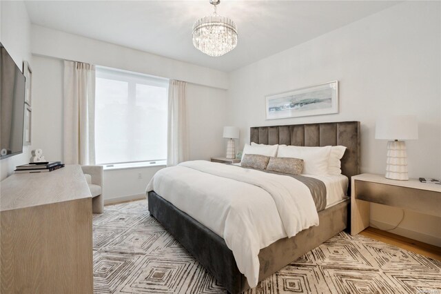 bedroom with a chandelier and light hardwood / wood-style floors