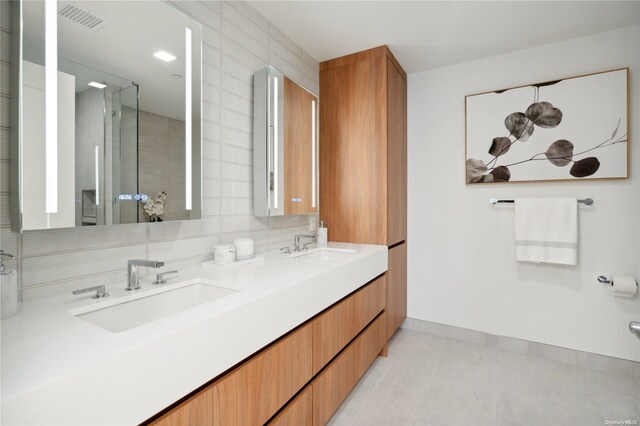 bathroom with backsplash, tile patterned flooring, and vanity