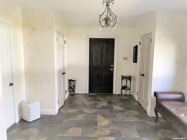 foyer entrance featuring ornamental molding and an inviting chandelier