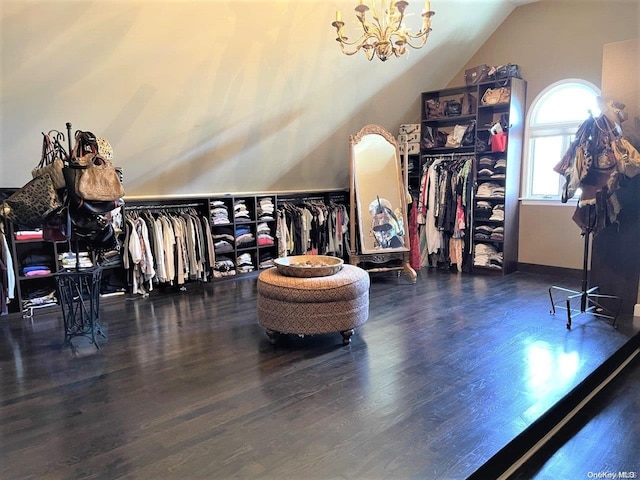 walk in closet featuring dark hardwood / wood-style flooring, vaulted ceiling, and a notable chandelier