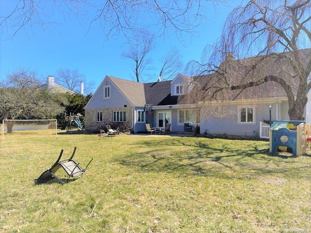 back of property featuring a playground, a patio area, and a yard