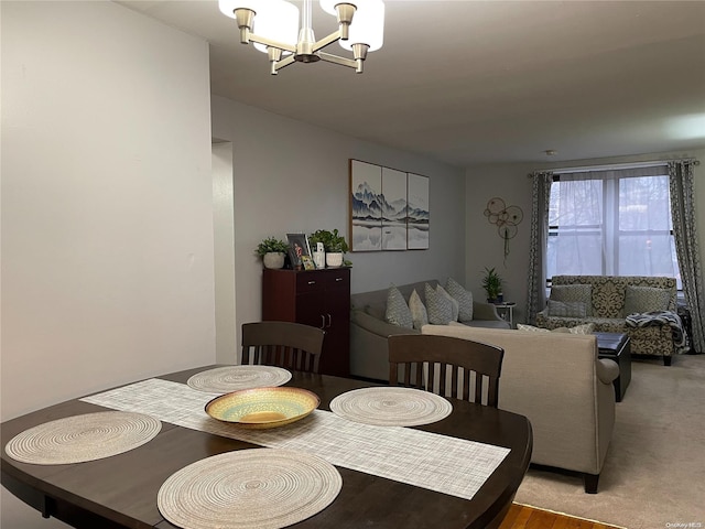 dining area featuring light colored carpet and an inviting chandelier