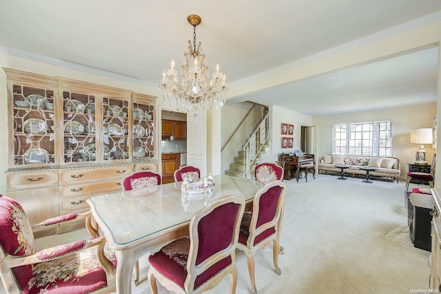 dining room featuring a chandelier, light colored carpet, and ornamental molding