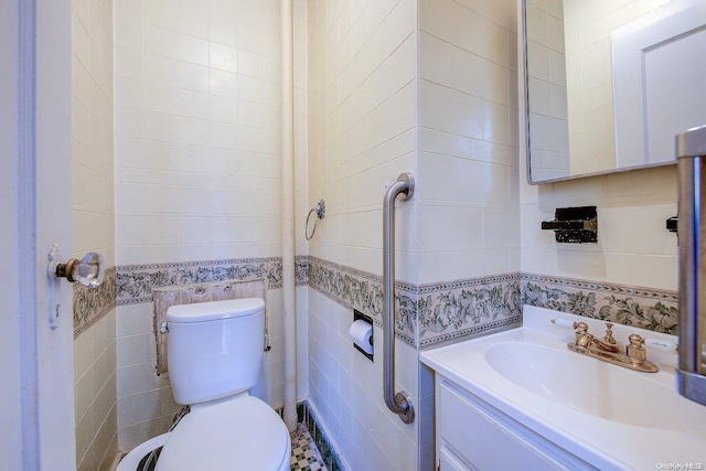 bathroom featuring vanity, tile walls, and toilet