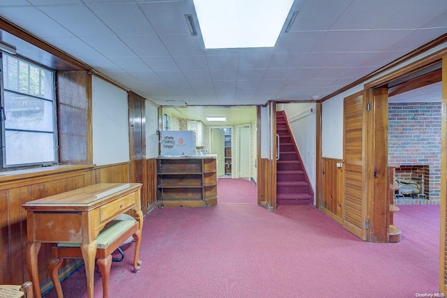 basement featuring light carpet, ornamental molding, and wood walls