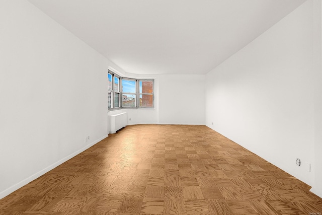 unfurnished room with light parquet flooring and radiator