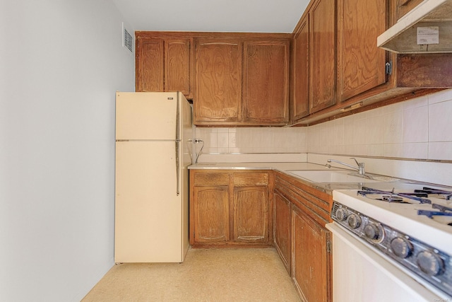 kitchen featuring sink, tasteful backsplash, and white appliances