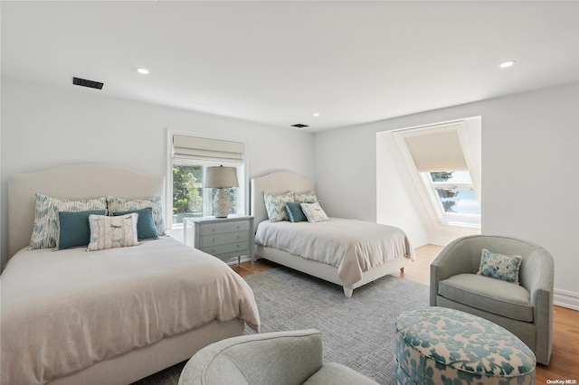 bedroom with multiple windows and hardwood / wood-style floors