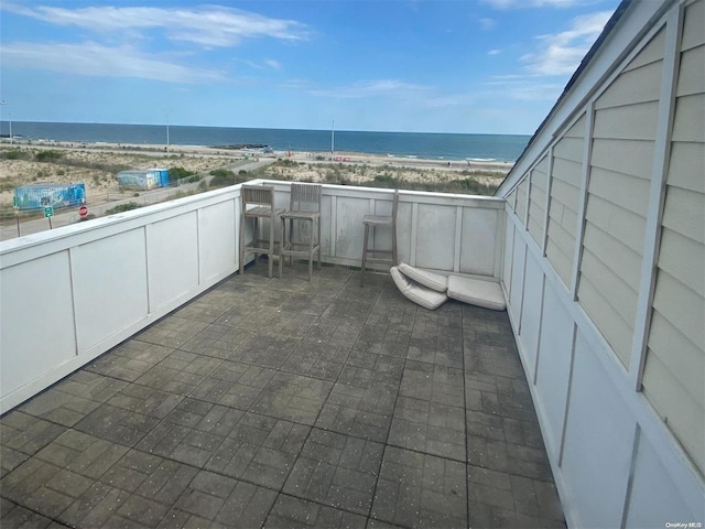 view of patio featuring a water view and a beach view