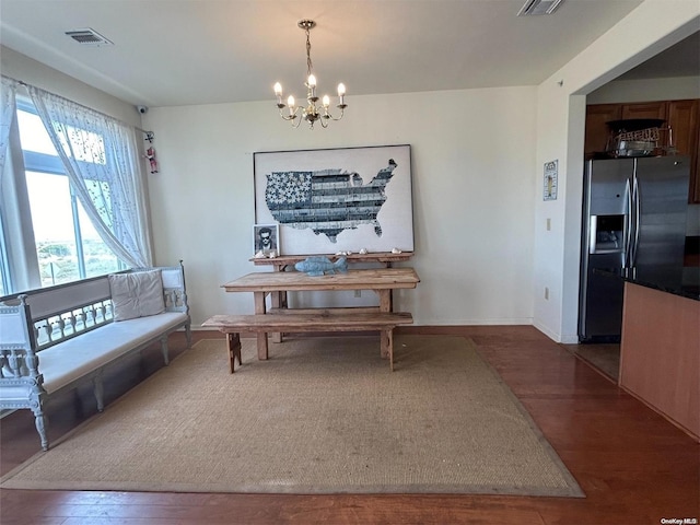 dining space featuring dark hardwood / wood-style floors and an inviting chandelier