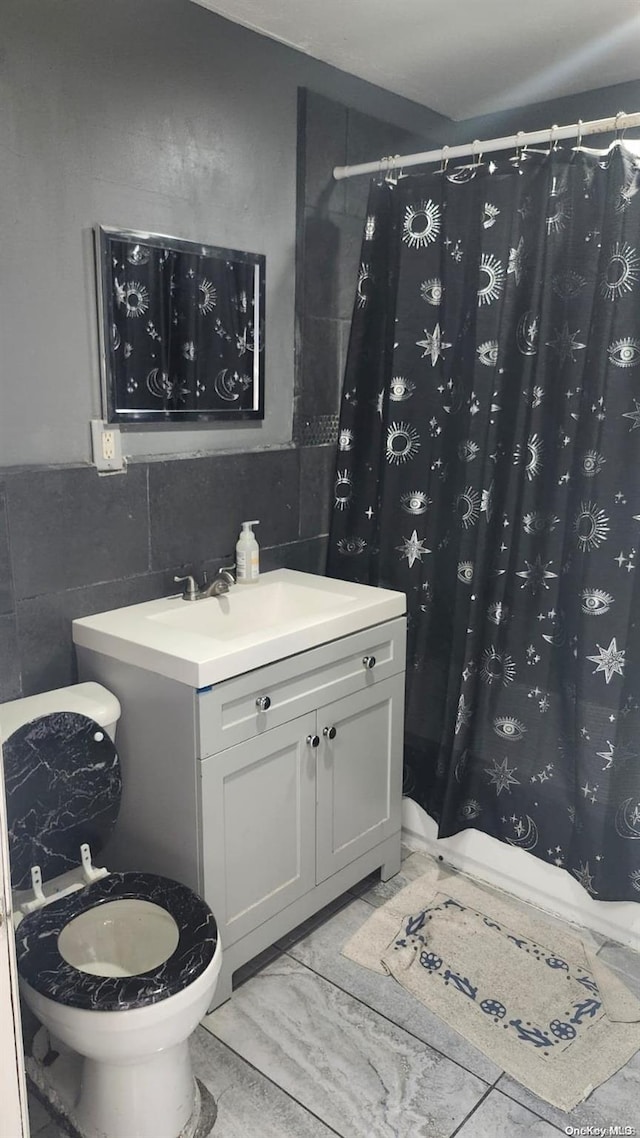 bathroom featuring vanity and tile walls