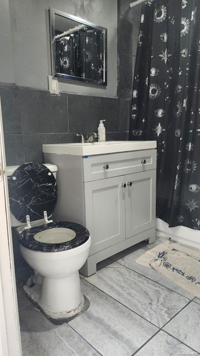 bathroom with vanity and tile walls