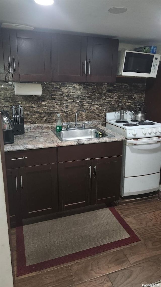 kitchen with sink, dark hardwood / wood-style floors, white appliances, decorative backsplash, and dark brown cabinets