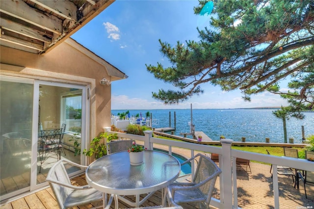 balcony with a deck with water view and a dock