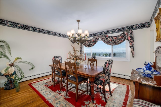 dining room with wood-type flooring, baseboard heating, and an inviting chandelier