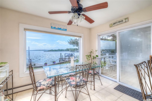 dining room featuring light tile patterned floors, a water view, a wealth of natural light, and ceiling fan