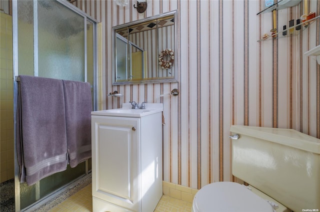 bathroom featuring vanity, toilet, and a shower with shower door