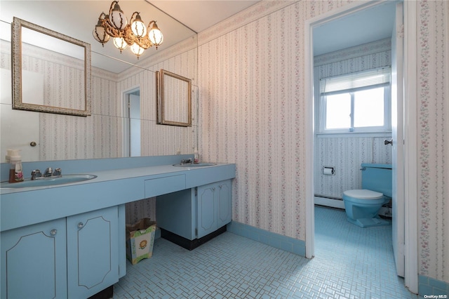 bathroom with tile patterned floors, vanity, baseboard heating, a notable chandelier, and toilet