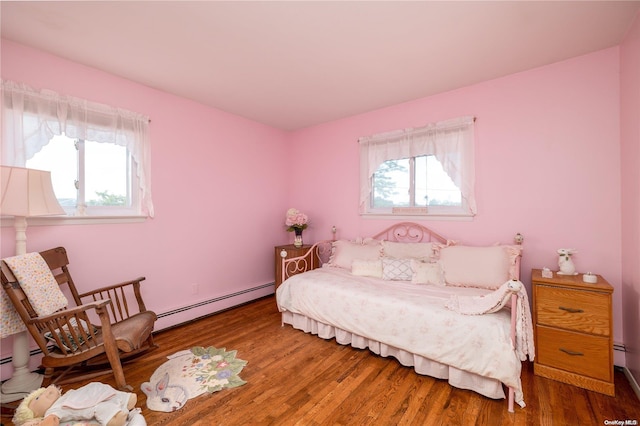 bedroom with a baseboard radiator and hardwood / wood-style flooring