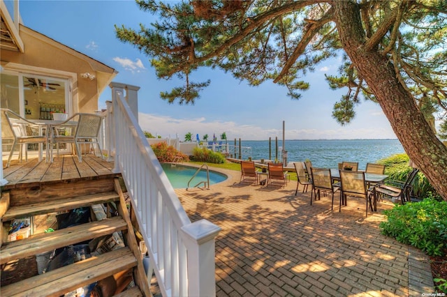 view of pool with a patio and a water view