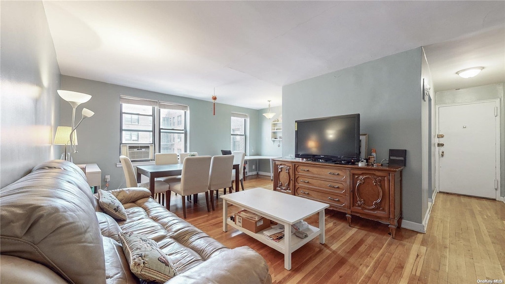 living room with cooling unit and light wood-type flooring