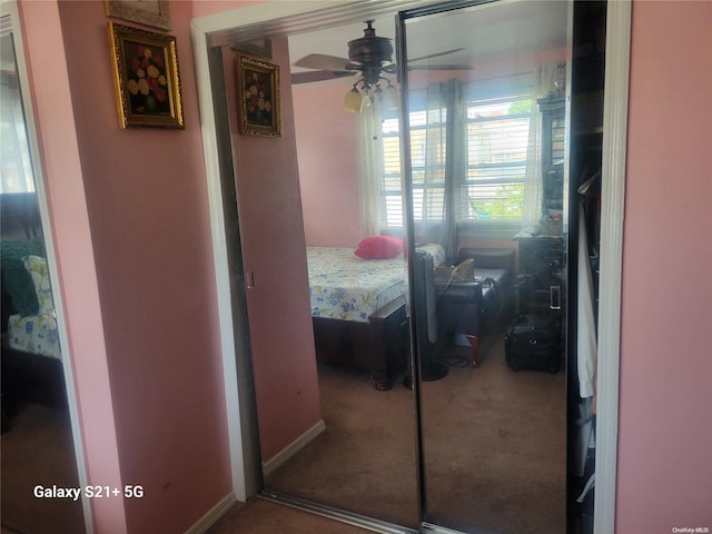 carpeted bedroom featuring ceiling fan and a closet