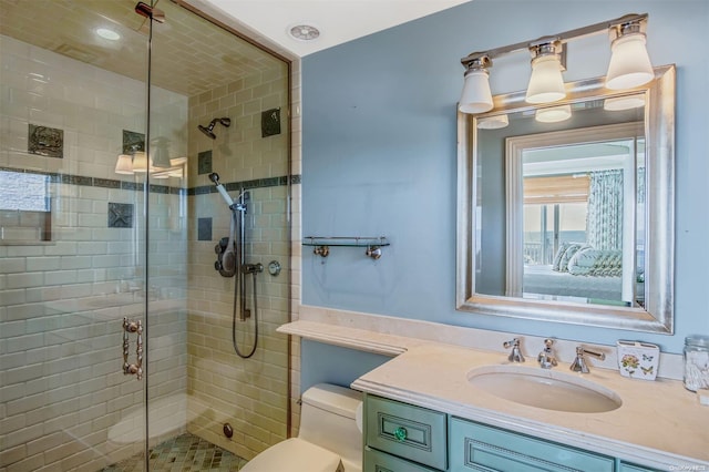 bathroom featuring vanity, toilet, and an enclosed shower