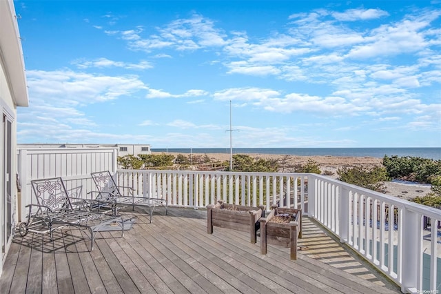 deck featuring a water view and a beach view