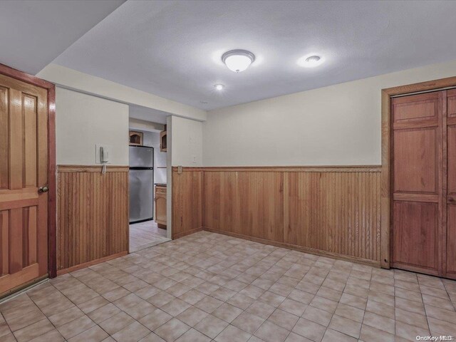 empty room with wood walls and a textured ceiling