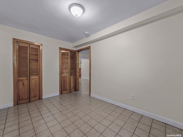 unfurnished bedroom featuring a closet and light tile patterned floors