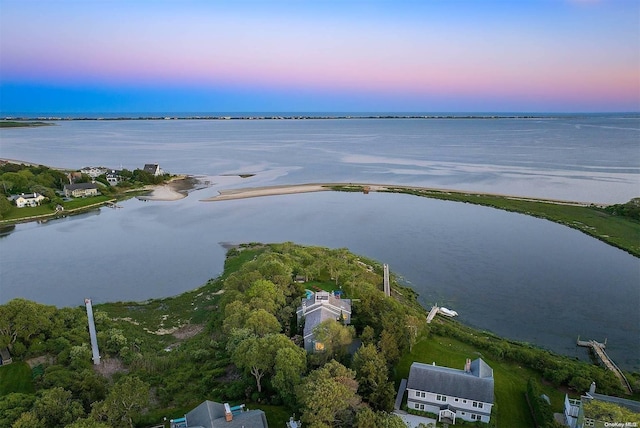 aerial view at dusk featuring a water view