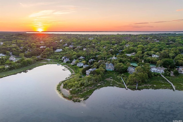 aerial view at dusk featuring a water view