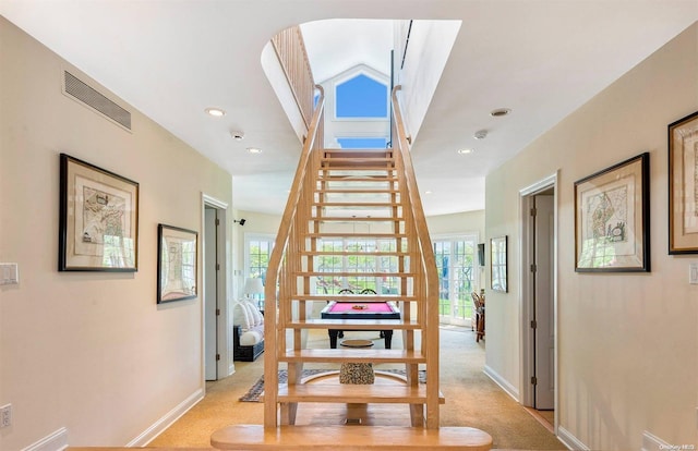 staircase featuring carpet flooring and vaulted ceiling