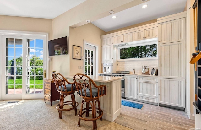 134 Middle Pond Rd, Southampton, NY 11968 - kitchen featuring appliances with stainless steel finishes, plenty of natural light, a breakfast bar area, decorative backsplash, and recessed lighting