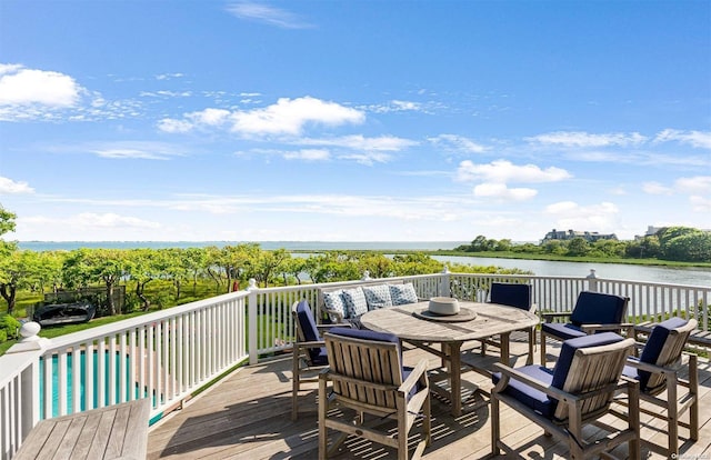 wooden deck featuring a swimming pool and a water view