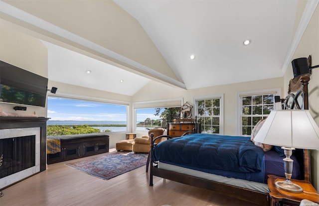 bedroom featuring wood-type flooring, a water view, and high vaulted ceiling