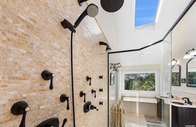 bathroom featuring vanity, independent shower and bath, and brick wall