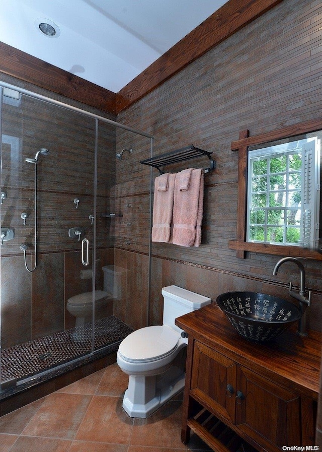 bathroom featuring tile patterned flooring, vanity, toilet, and an enclosed shower