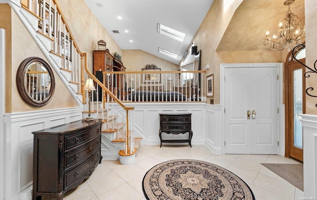 foyer featuring light tile patterned floors, a chandelier, and lofted ceiling