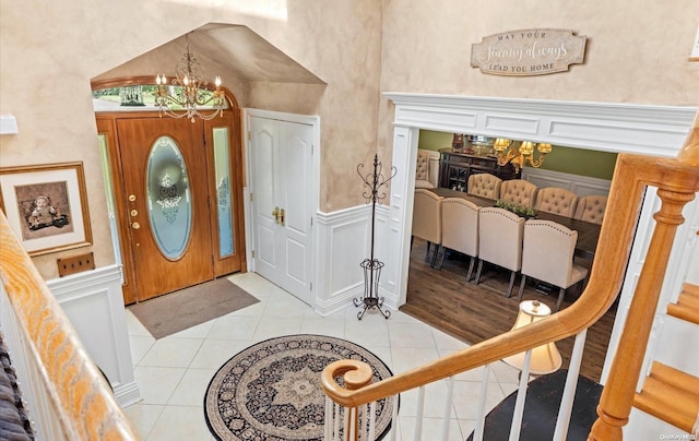 tiled entrance foyer with a chandelier