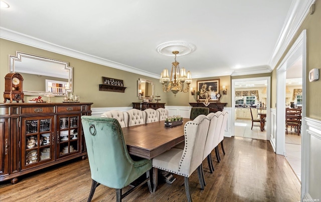 dining room featuring hardwood / wood-style floors, ornamental molding, and an inviting chandelier