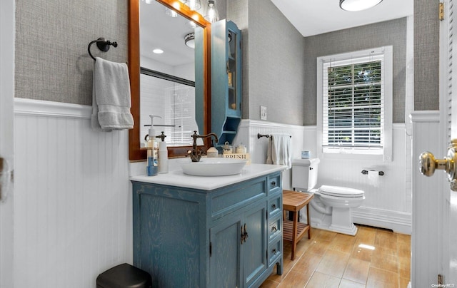 bathroom featuring vanity, toilet, and a shower with door