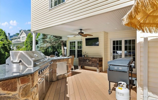 wooden deck featuring area for grilling, ceiling fan, sink, and grilling area